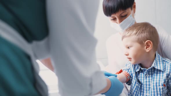 Little Boy is Taking Blood From a Vein for Analysis alt
