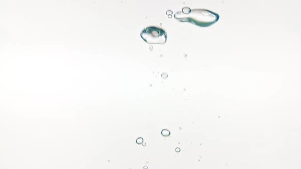 Slow Motion of Falling Lemon Slices in Water and Air Bubbles on White Background alt