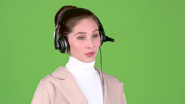Manager in the Call Center Talks To the Customers on the Headset. Green Screen. Slow Motion alt