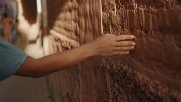 Close Up Women Hand Touches a White Concrete Wall with Sunshine, Shade and Shadow in the Morning alt