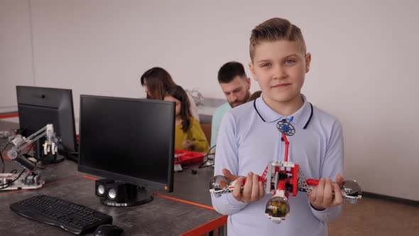 Schoolboy with a Robot That He Himself Assembled in Robotics Lessons at School alt