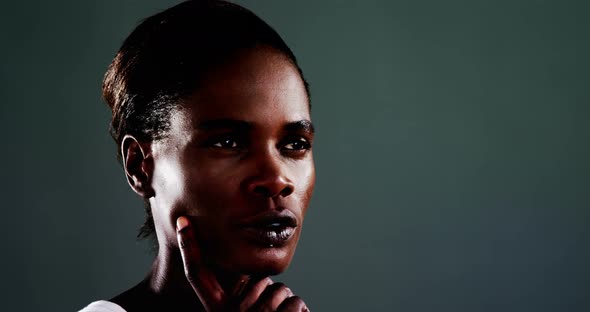Androgynous man posing against dark background alt