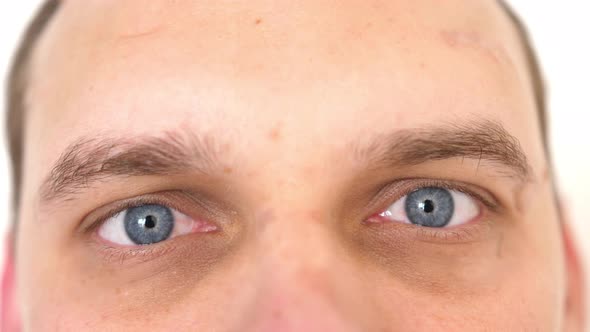 Closeup of a Surprised Scared Emotional Man with Blue Eyes Looking Into the Camera