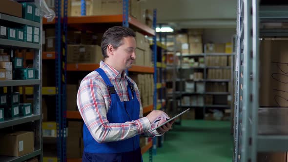 Happy Caucasian Man or Manager with Tablet Pc Computer Checking Goods at Warehouse. Wholesale