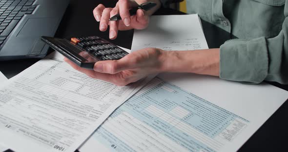 Woman Calculate and Filling US Tax Form 1040 alt