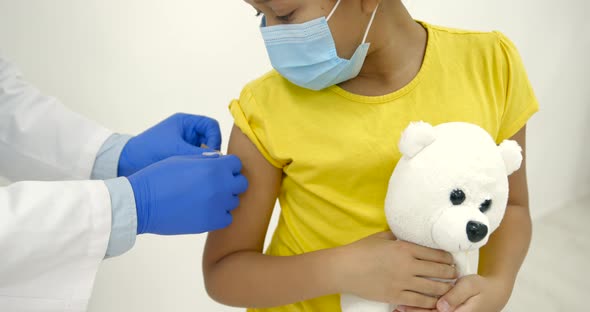 Male Pediatrician Giving a Vaccine Shot to a Black Kid alt