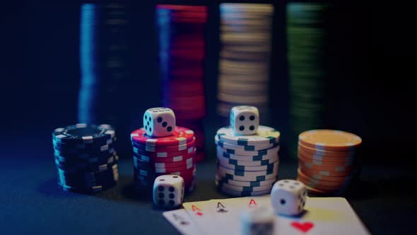 Casino Chips with Dice and Playing Cards on a Dark Table alt
