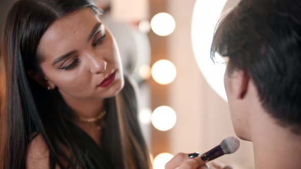 Make Up Artist Applying Powder on the Face of Male Model Using a Fluffy Brush alt