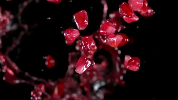 Ripe Pomegranate Grains Are Bouncing with Splashes of Red Juice alt