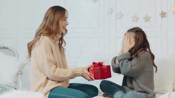 Smiling Girl Closing Eyes in Luxury House. Pretty Mother Presenting Gift alt
