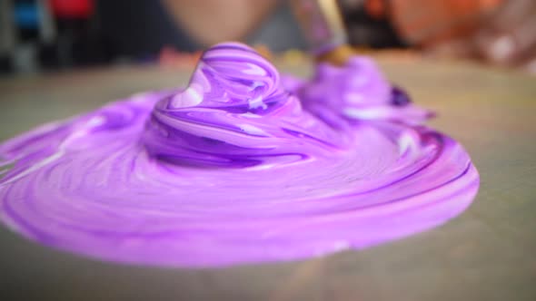 Closeup Shot of Artist Holding Paint Brush and Mix Color on Wooden Palette alt