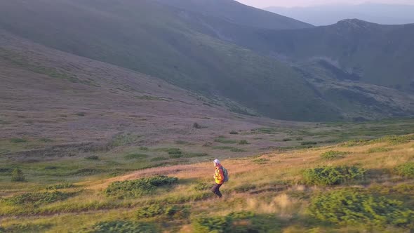 Tourist Hiker with a Backpack Running on Mountain Path in Carpathian Mountains alt