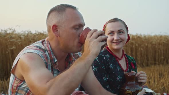 the Girl Brought the Farmer Dinner a Piece of Bread and a Jug of Milk He Drinks Milk From a Cup and alt
