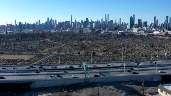 An aerial time lapse over warehouses by a highway. It was taken on a sunny day. The camera truck lef alt