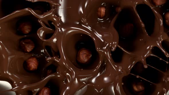 Super Slow Motion Shot of Hazelnuts Falling Into Melted Chocolate at 1000 Fps alt