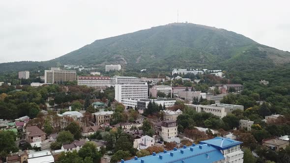 Aerial view on the small Russian town on the background of the hill. Trees along with houses. Drivin alt