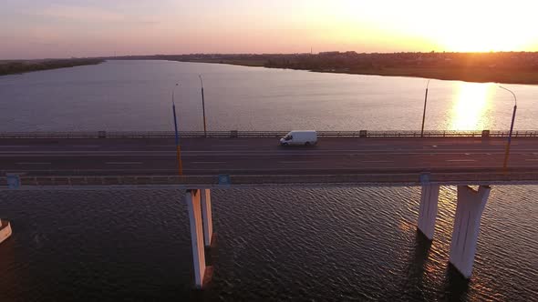 Aerial Shot of Large Bridge with a Moving Minibus at Golden Sunset in Summer