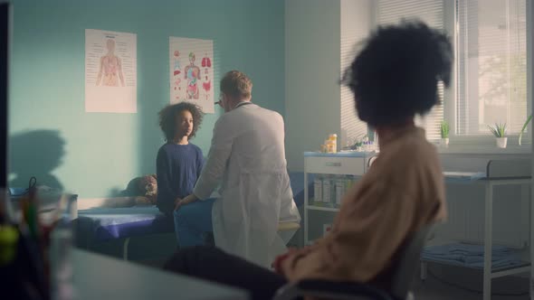 Man Doctor Checking Preteen Kid Reaction in Office Clinic alt