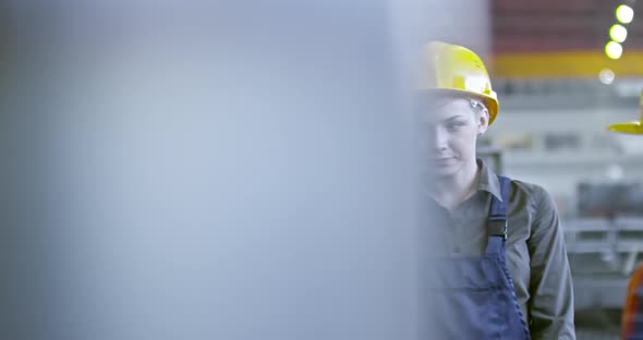 Experienced Female Factory Technician Teaching Young Employees alt