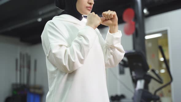 Arab Athlete a Muslim Standing in the Pose of a Fighter Boxing in a Fitness Center Wearing a White