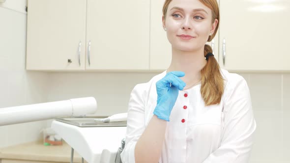 Portrait of Beautiful Smiling Dentist in Office Clinic