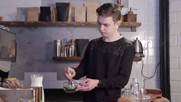 Man preparing Matcha green tea. Barista mixing Matcha tea.