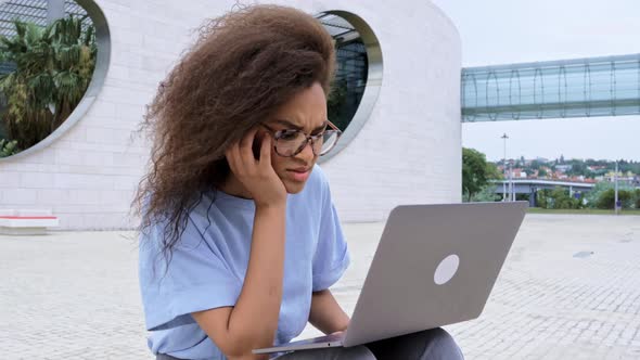 Stressed Tired African American Young Business Woman Freelancer Manager Sits Outside Massages Her alt