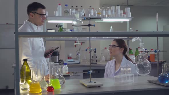 Colleagues at Work Talking About Research and Smiling alt