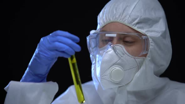 Worker of Illegal Fuel Lab Holding in Hands Test Tube With Flammable Additive alt