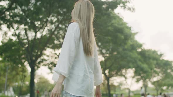 A beautiful Asian woman closed her eyes enjoying the breeze in the public park.