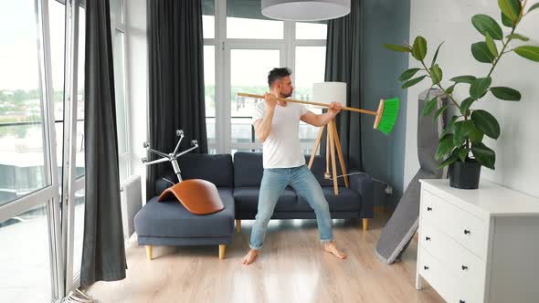Man Cleaning the House and Having Fun Dancing with a Broom alt