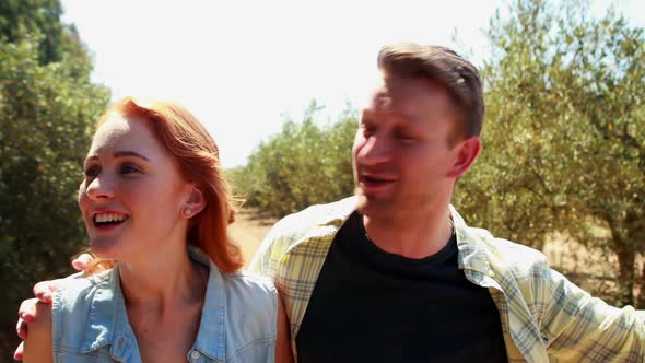 Happy couple interacting with each other in olive farm 4k alt