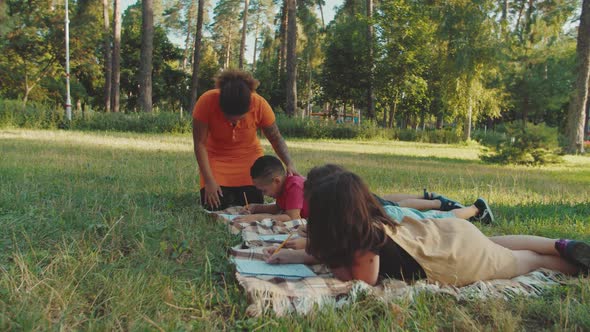 Side View of Multiethnic Diverse Pupils Writing Exam Test Outdoors alt