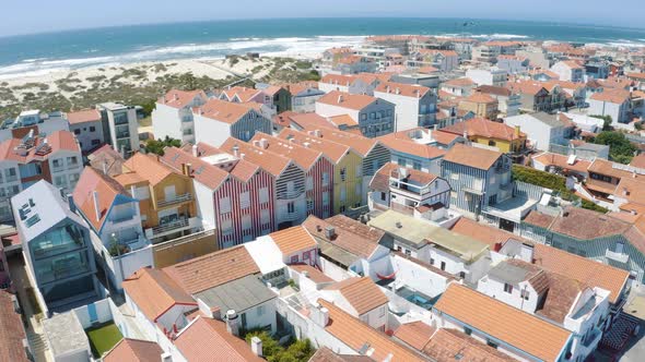 Flying over Costa Nova Do Prado in Portugal, street with colorful and striped houses 4K
