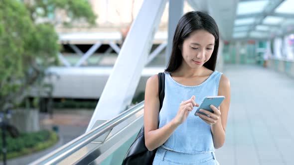 Woman using cellphone at outdoor  alt