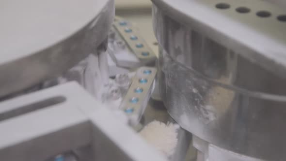 Closeup of Automated Chemical Equipment Capsulating Blue Capsules at Pharma Plant