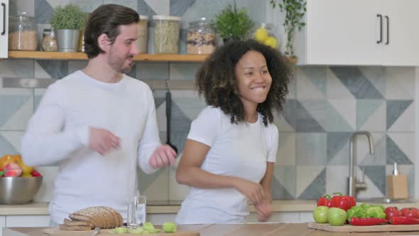 Mixed Race Couple Dancing in Kitchen alt