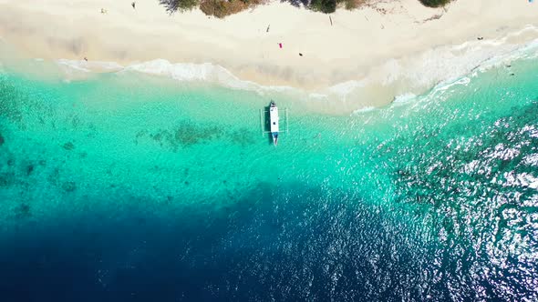 Top view of traditional boat anchoring on shoreline of tropical island with white sandy beach washed alt