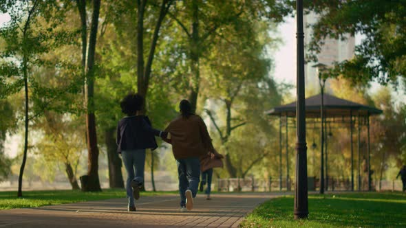 Family Resting Autumn Park Running Path Together Rear View alt