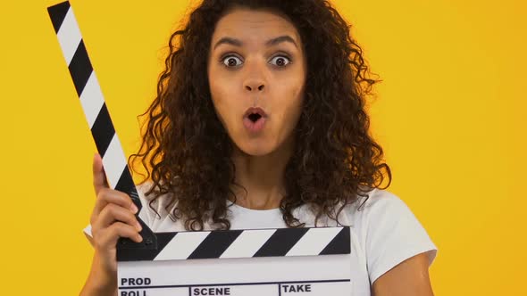 Astonished Girl Using Clapper Board, Shocking Content, Highest-Rated Movie alt