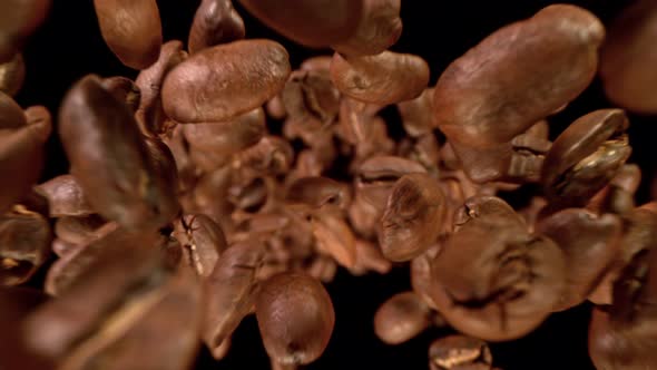Super Slow Motion Detail Shot of Coffee Beans Flying Towards Camera at 1000Fps alt