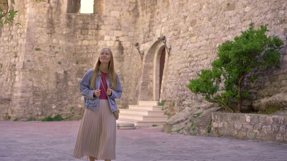A Young Woman Visits the Old Town of Budva in Montenegro alt