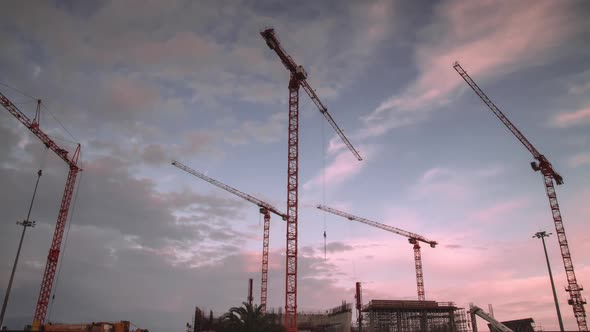 Construction site at night Time Lapse. Working tower cranes, buildings and traffic