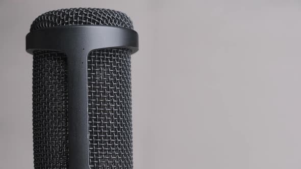 Studio Condenser Microphone Rotates on Gray Background with Place for Text alt