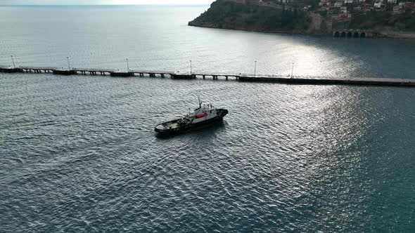 Ship tug sails out of port aerial view Turkey Alanya 4 K alt