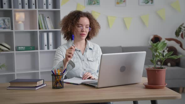 Distance Training Young Woman at Conference Online Communicates Via Video Communication on Laptop alt