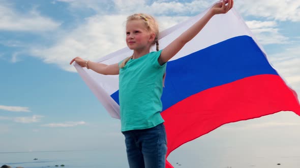Blonde Girl Waving National Russia Flag Outdoors Over Blue Sky at Summer Russian Flag Country alt