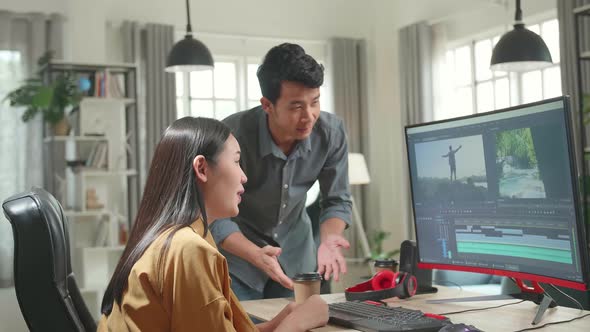 Female Video And Sound Editor Works With Her Male Colleague And Arguing On A Project On Computer alt