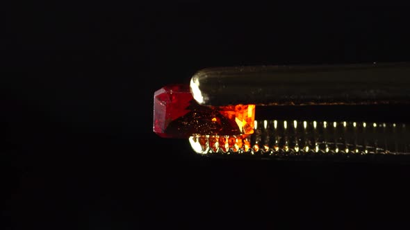 Natural Hessonite Brown Garnet Gemstone in the Tweezer on the Turn Table alt