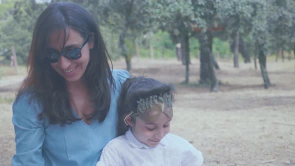 Little girl laying on her mother's lap in the countriside